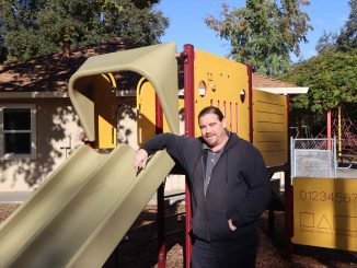Facilities manager stands at a community playground